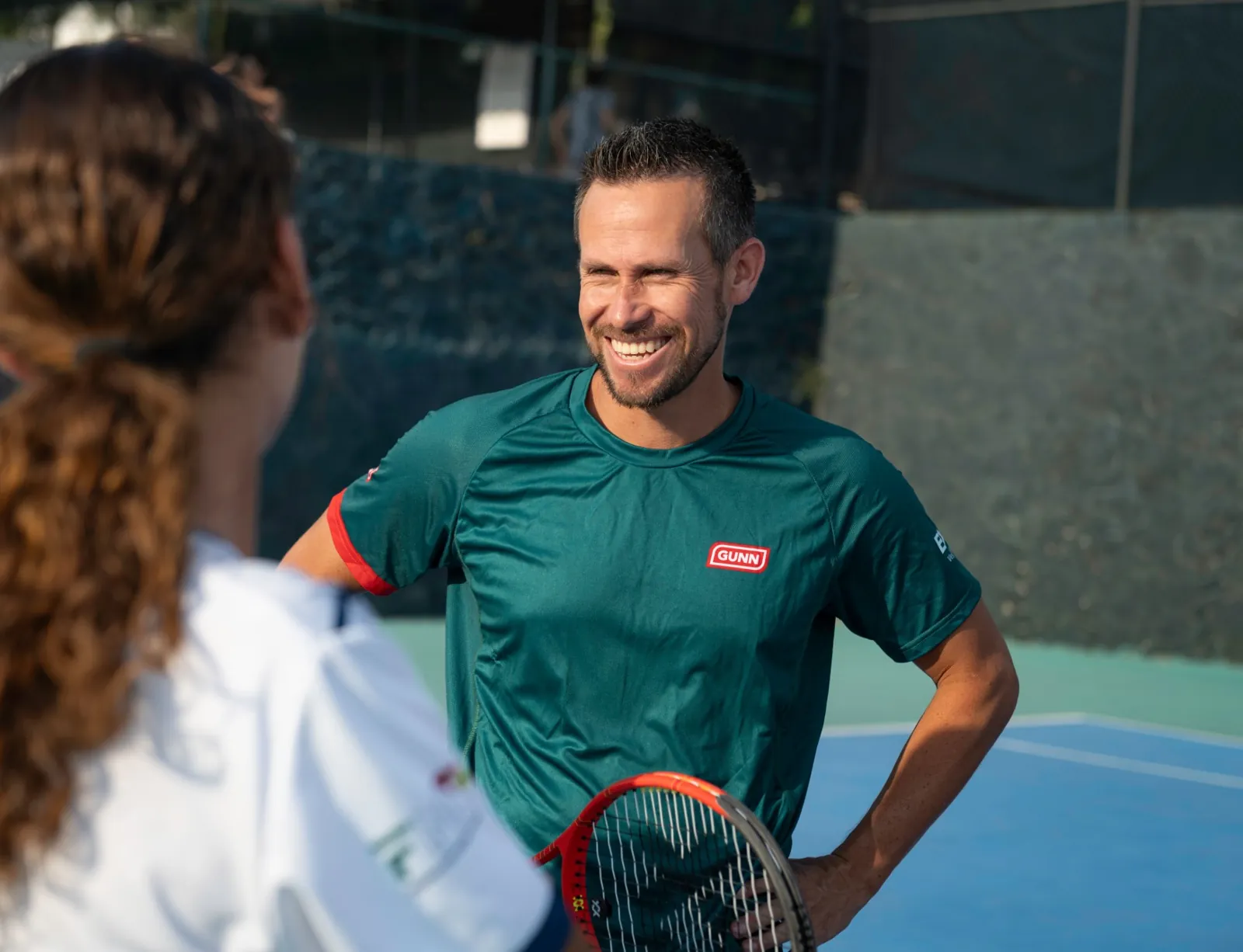 Miguel speaks with students during a tennis clinic.